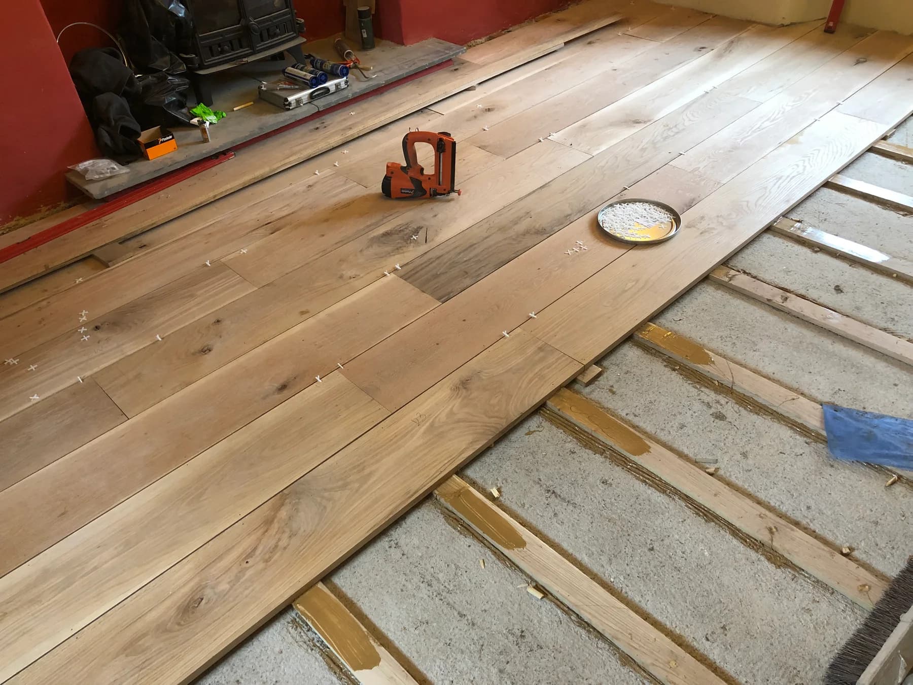 Timber flooring being fitted beside exposed subfloor during an interior installation.