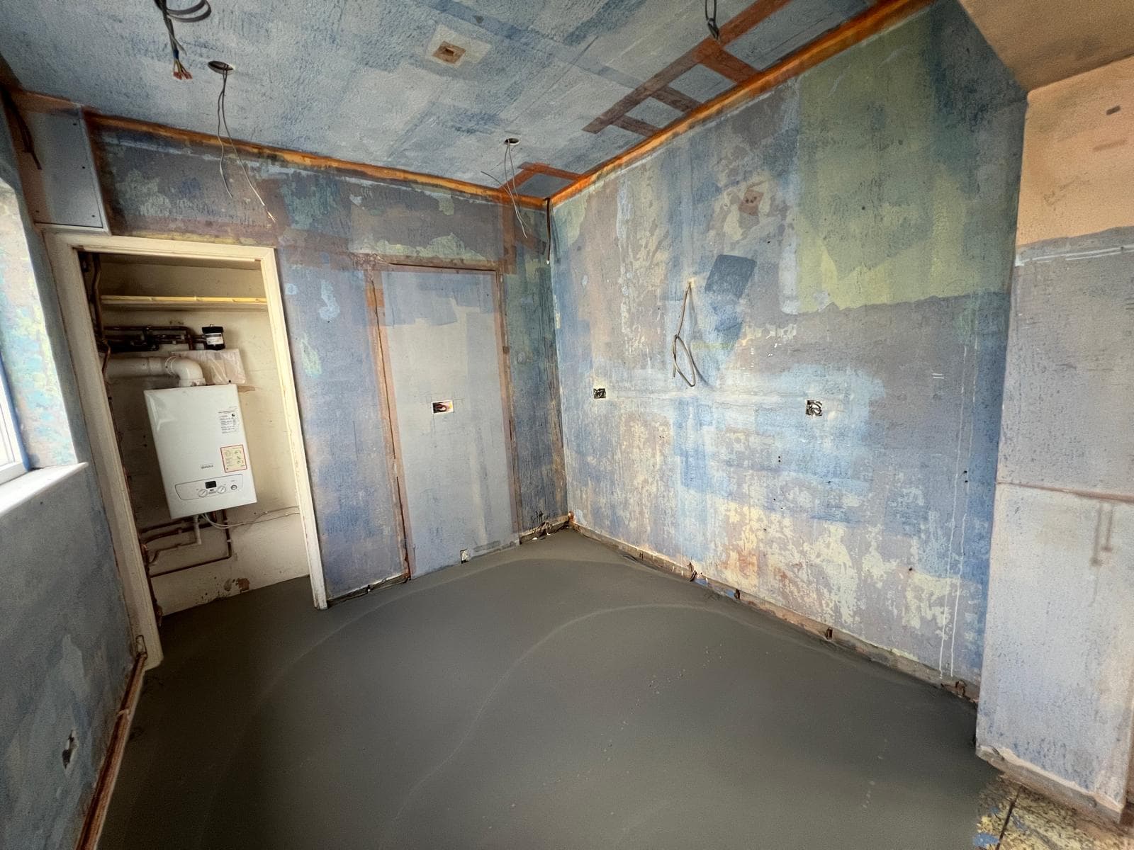 The room stripped back to bare walls and floor before the kitchen refit by Truscon
