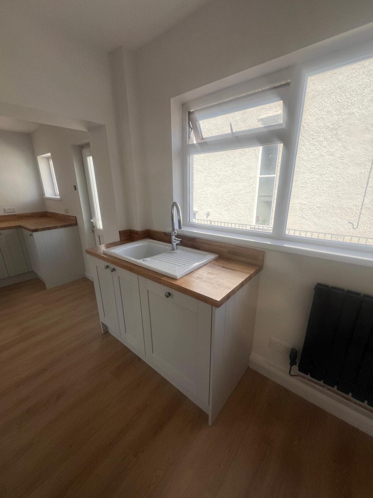 Shaker units and ceramic sink under the window, fitted by Truscon