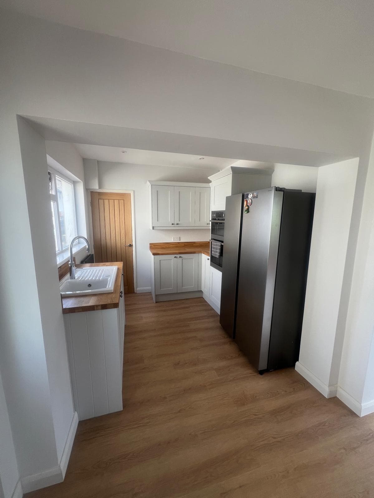 Galley kitchen with shaker units, oak worktops and new flooring, fitted by Truscon