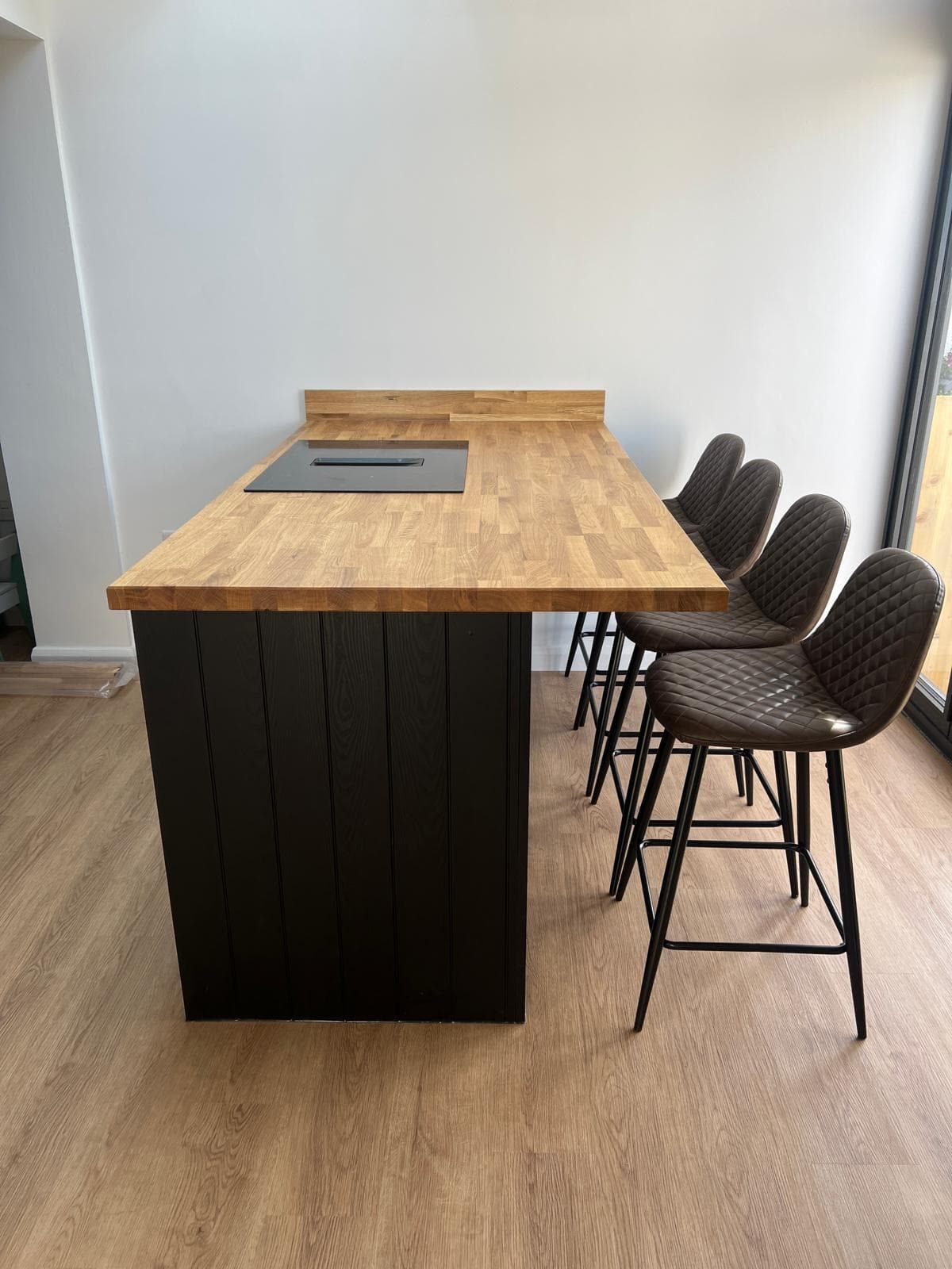 Black kitchen island with oak worktop and bar stools, fitted by Truscon