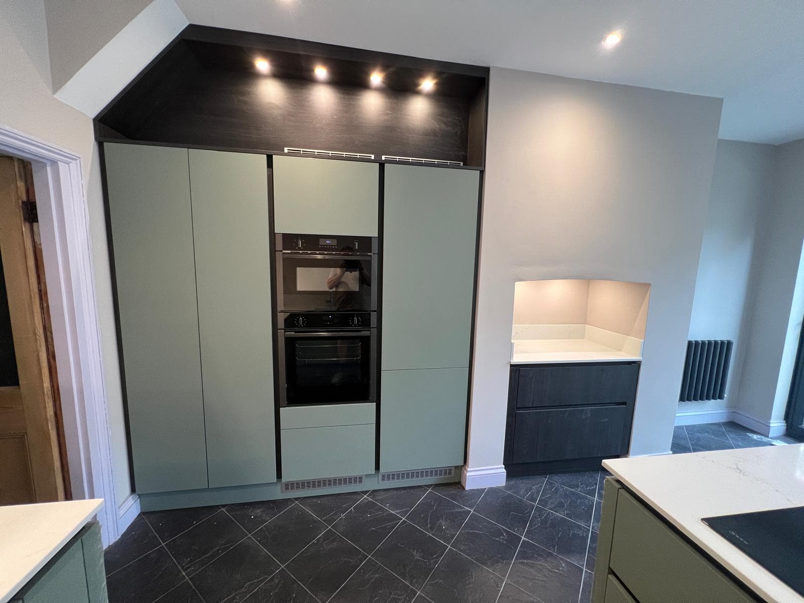 Handleless kitchen with tall units, double oven and island, fitted by Truscon