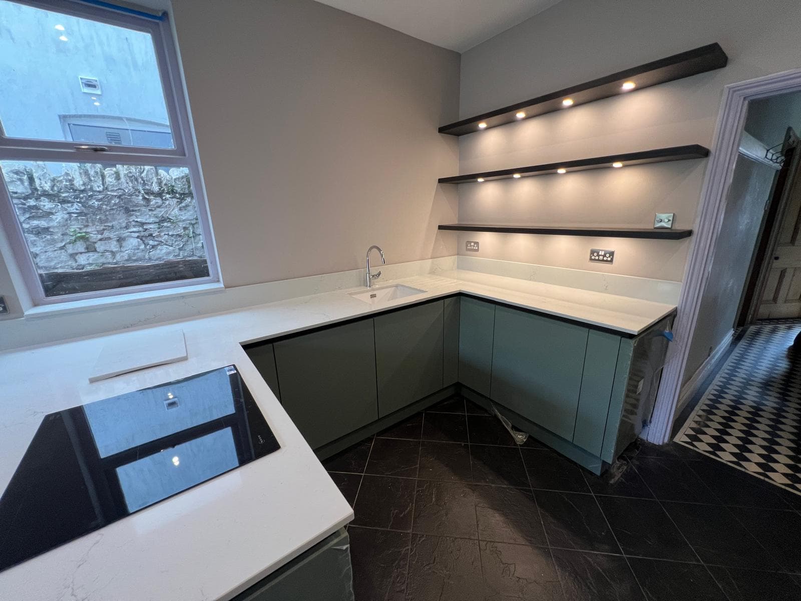 Quartz worktop, undermount sink and lit floating shelves, fitted by Truscon